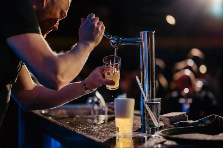 Barman tapt een biertje met een strakke schuimkraag aan de TapChallenge bar